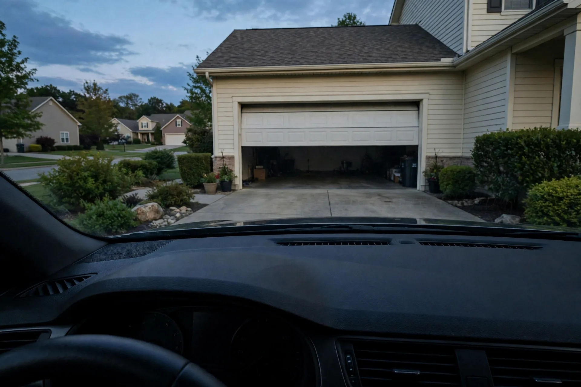 Car dashboard view with a garage door opening ahead